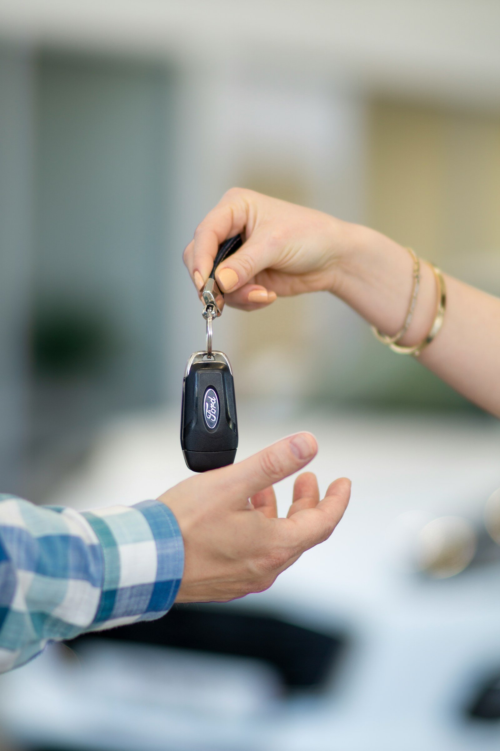 A car key being handed over at the vehicle